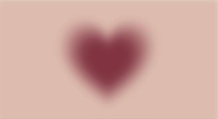 a blurry image of a heart on a pink background