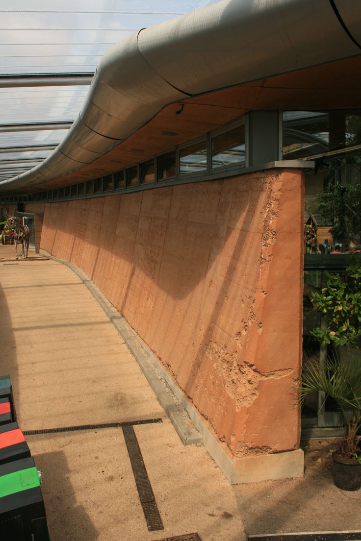 the side of a building that is made out of concrete and has a curved roof