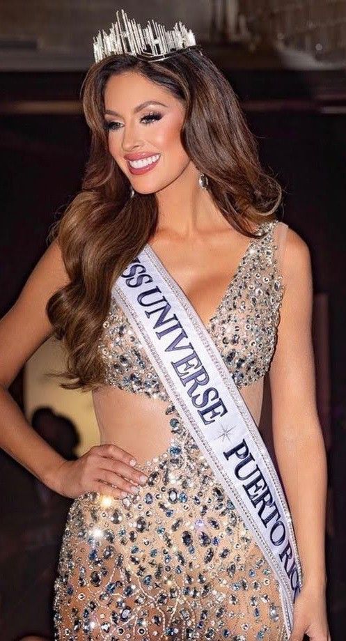 a woman in a dress and tiara posing for the camera with her hands on her hips