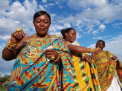 women in colorful clothing are dancing on the grass