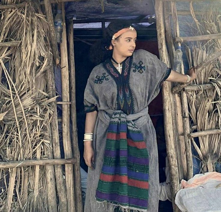 a woman standing in the doorway of a hut