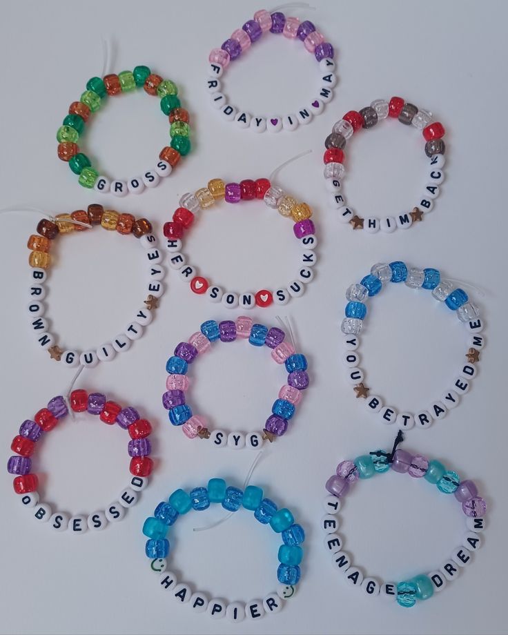 six bracelets with words on them and beaded around the edges, all in different colors