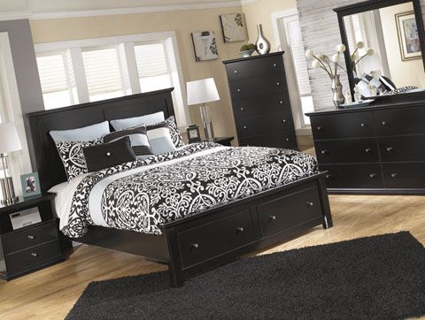 a bedroom with a bed, dressers and mirror in it's center area