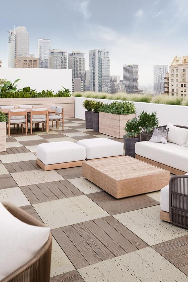 an outdoor living area with couches, tables and chairs in front of the city skyline