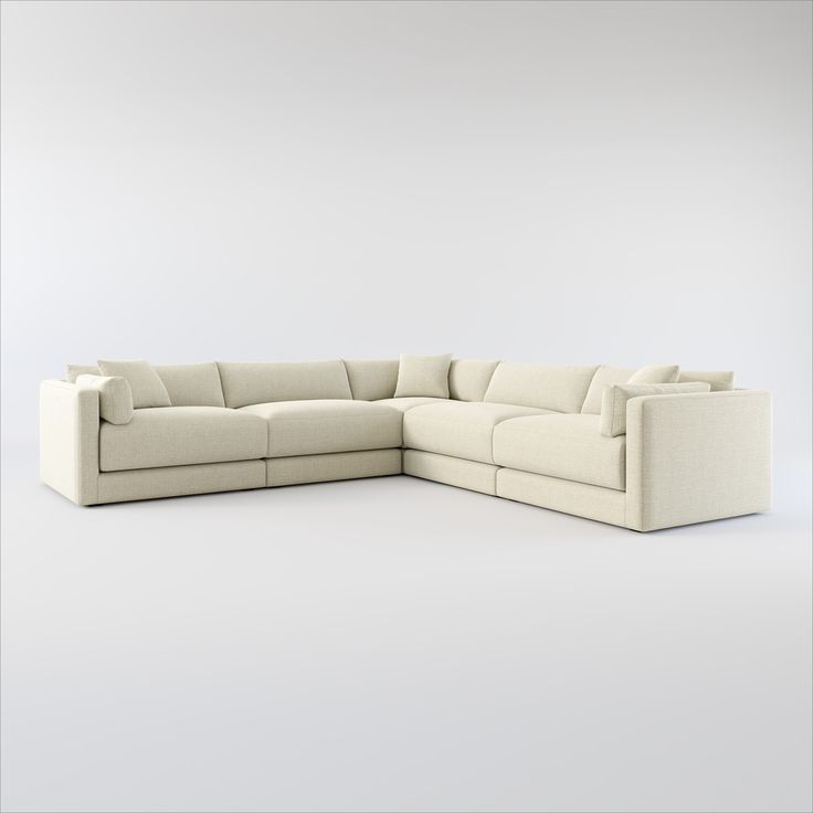 a white sectional couch sitting on top of a white floor