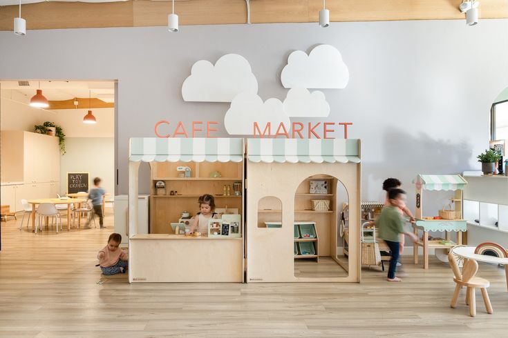 the children are playing in the play area at the cafe market, which is open for business