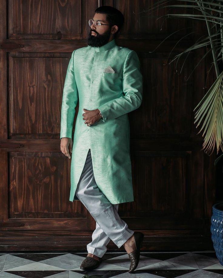 Raw silk, Mint green sherwani with invisible, front buttons Ankle length, white pants. Traditional Green Silk Sherwani, Designer Green Kurta For Festive Occasions, Green Silk Traditional Wear With Long Sleeves, Fitted Green Nehru Jacket With Dabka Detailing, Green Long Sleeve Silk Traditional Wear, Designer Green Nehru Jacket For Festive, Designer Green Nehru Jacket For Festive Season, Fitted Green Nehru Jacket For Eid, Green Nehru Jacket For Eid And Formal Occasions