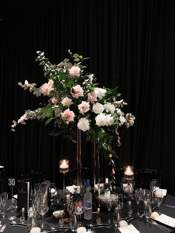 a table is set with flowers, candles and place settings for an elegant dinner party