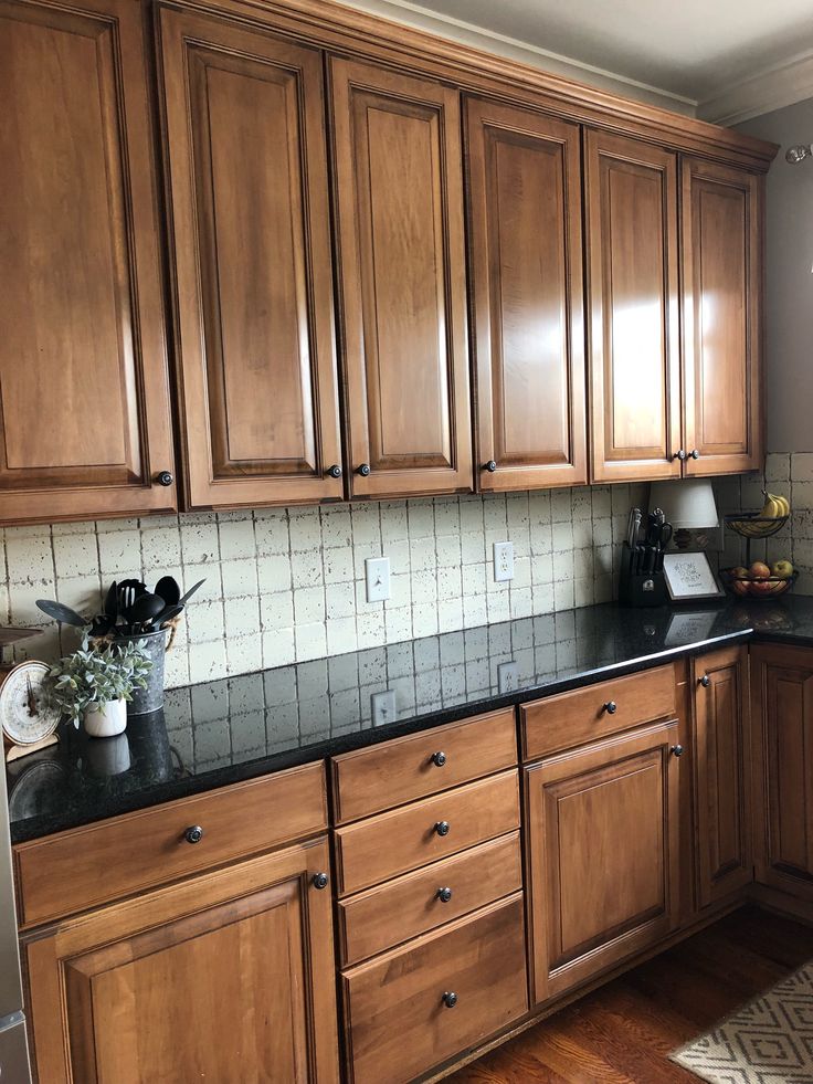 a kitchen with wooden cabinets and black counter tops