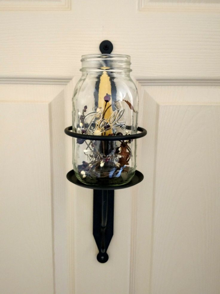 a glass jar hanging from the side of a door with an image of a boat in it