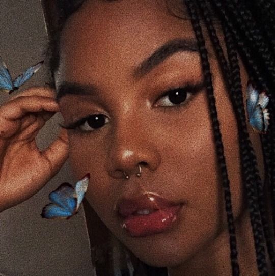 a close up of a person with butterflies on her face