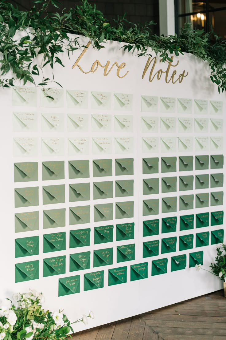 A green seating chart for wedding reception with greenery and flowers surrounding it. Perfect for a wedding that has green in their color palette. The couple wrote a note to each guest. Wedding Seating Assignment Display, Matches Seating Chart, Emerald Seating Chart, Wedding Favors Seating Chart, Reception Seating Chart Layout, Golf Course Seating Chart, Thank You Note Seating Chart, Seating Chart Favor Ideas, Personalized Seating Chart