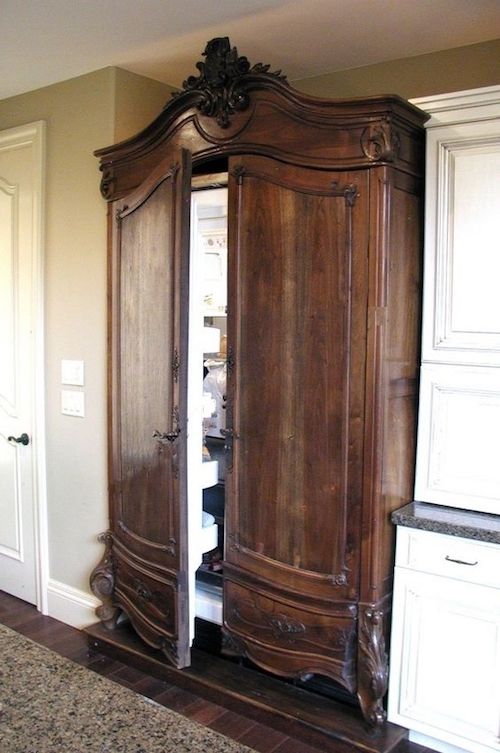 a large wooden armoire in the corner of a room