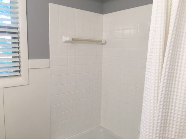 a bathroom with a white shower curtain next to a window