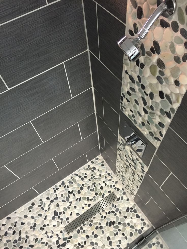 a tiled shower stall with black and white tile