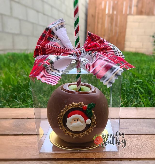 a chocolate covered candy with a santa clause on it and a candle in the center