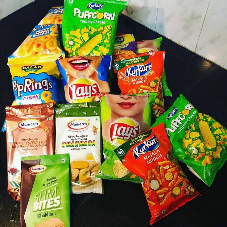 a pile of snacks sitting on top of a counter next to a bag of chips