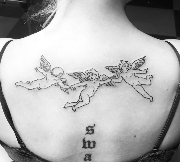 the back of a woman's shoulder with two cherubs on it and an inscription