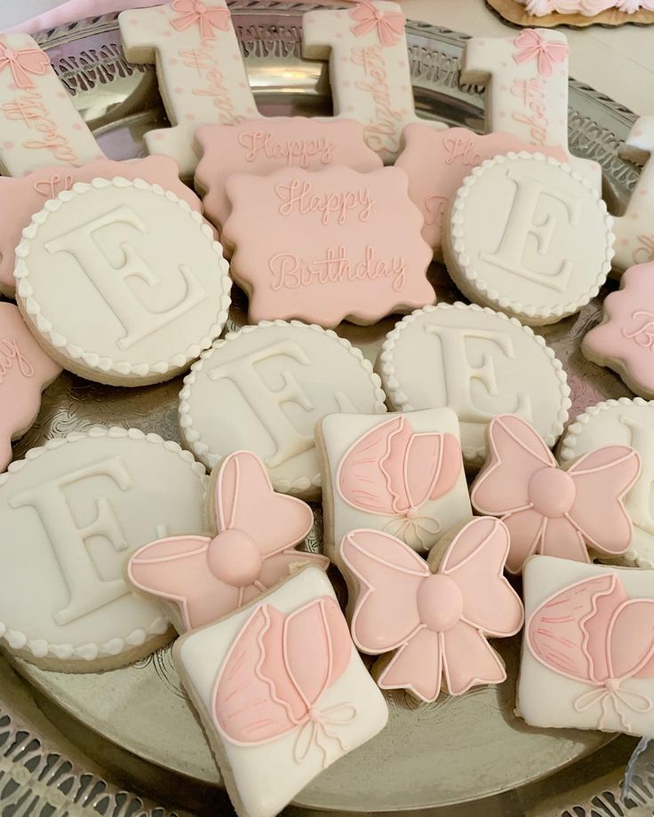 decorated cookies are arranged on a platter for a baby's first birthday party