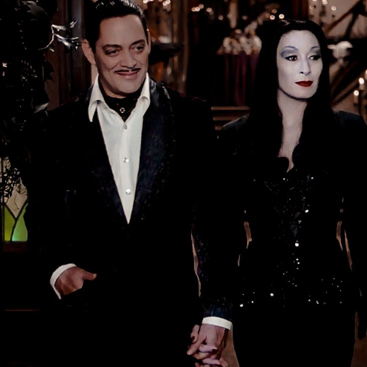 the man and woman are dressed up in black outfits with white make - up on their faces