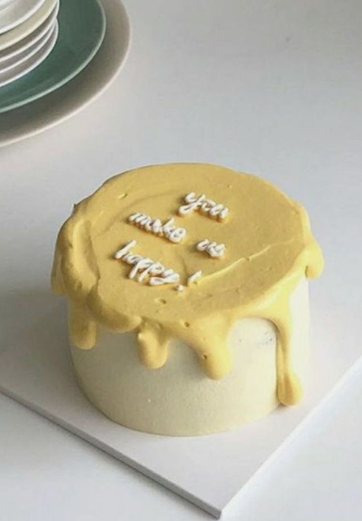 a cake with yellow icing sitting on top of a table