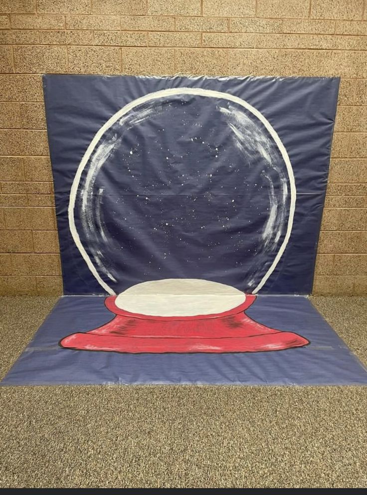 a blue and red object sitting on top of a floor next to a brick wall