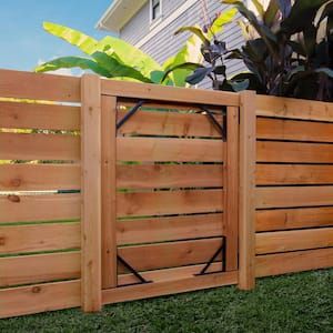 a wooden fence with an iron gate in the middle