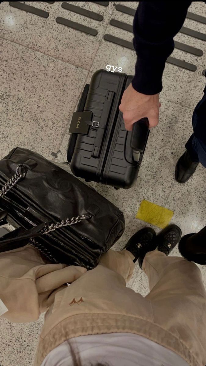 a man is standing next to his luggage on the ground