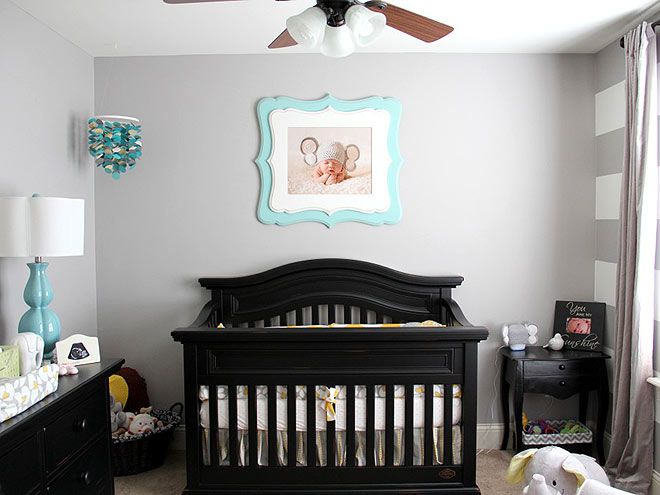 a baby's room with a black crib and blue accents on the wall