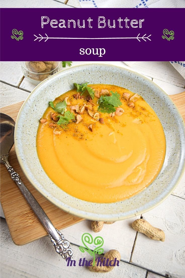 a white bowl filled with soup on top of a wooden cutting board next to nuts