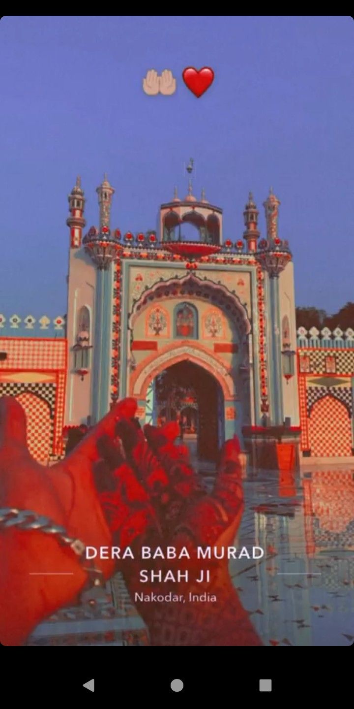 someone holding their hand up in front of a building with a red heart above it