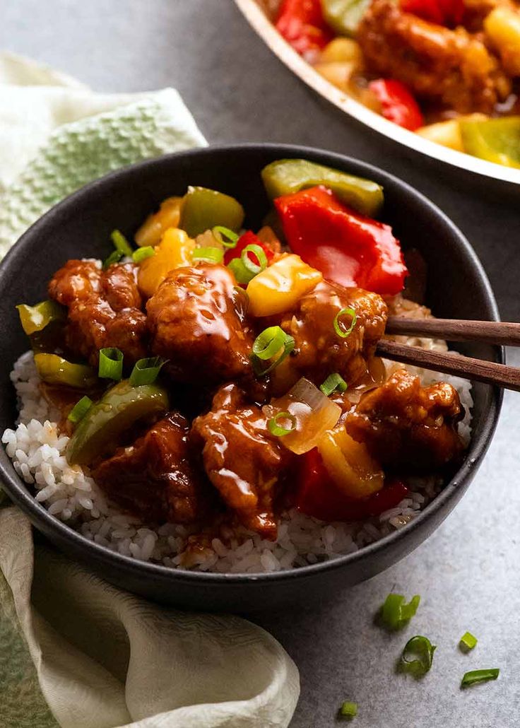 two bowls filled with meat and vegetables on top of rice