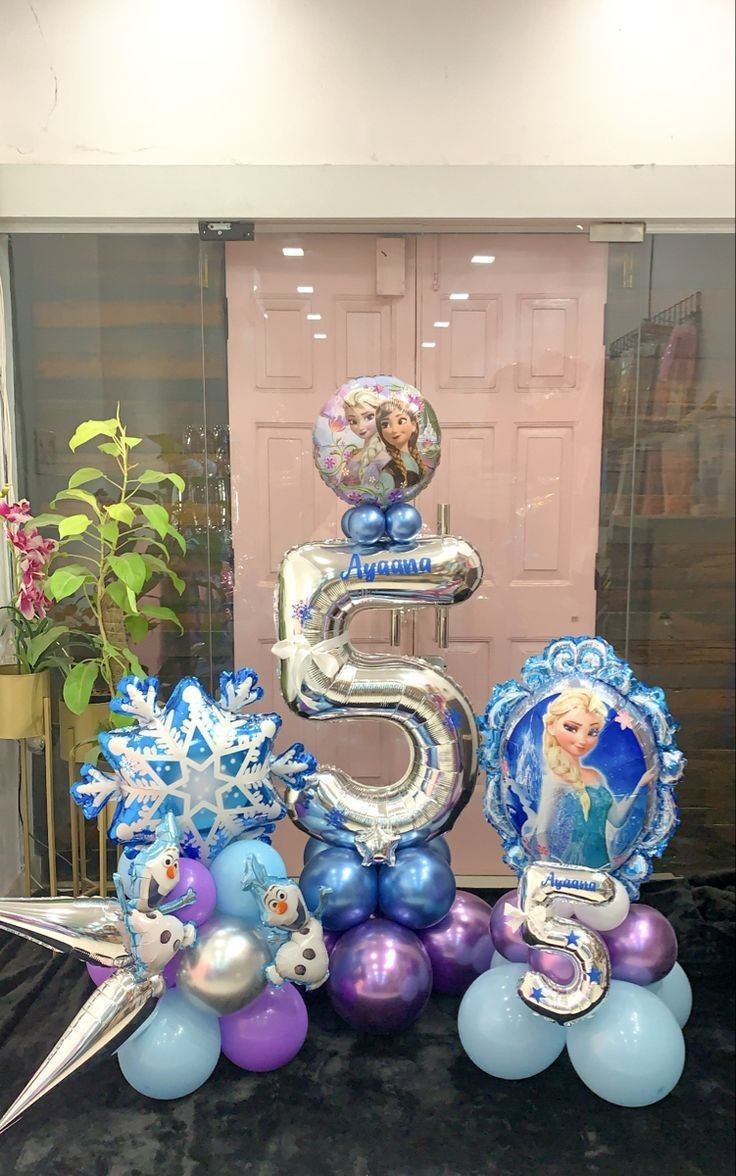 the number five is surrounded by balloons and decorations for a frozen princess themed birthday party