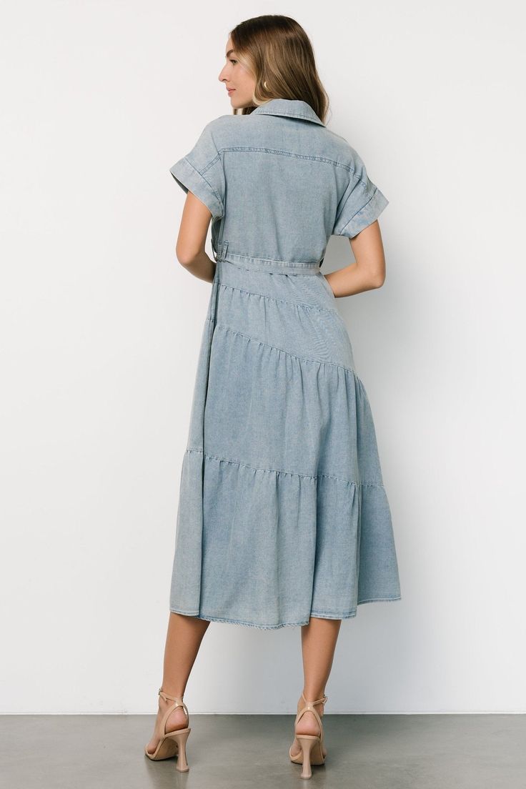 Baltic Born exclusive style Washed denim blue color Cotton-poly blend material has no stretch Collared Functional buttons down front of dress Cuffed short sleeves Removable self-tie waist sash Tiered skirt Unlined 90% Cotton, 10% Polyester Casey is 5'8, cup size 32B, size 2 and wearing size S Button Up Maxi Dress, Semi Casual, Baltic Born, Waist Sash, Dress Denim, Cuffed Shorts, Button Up Dress, 80 Dress, Tiered Maxi Dress