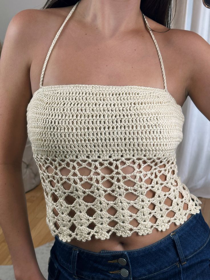 a woman wearing a crochet top and jeans