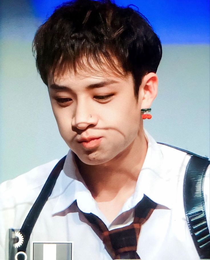 a young man wearing a tie and suspenders making a funny face with his tongue