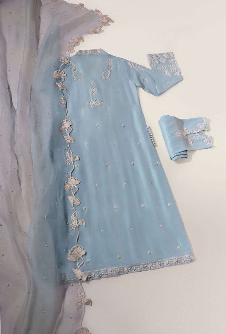 This beautiful three piece is designed on pure raw silk 58 Gms in an alluring ice blue tone with intricate embroidery alongside clusters of pearls on the long kameez and trousers. Paired with a regal cutwork matching pure organza dupatta. The length of the long kameez is 45 inches. An alluring three piece for your fest Unstitched Blue Tissue Silk Kurta, Blue Resham Embroidered Kurta In Tissue Silk, Blue Resham Embroidered Tissue Silk Kurta, Blue Tissue Silk Kurta With Dupatta, Blue Tissue Silk Kurta With Resham Embroidery, Blue Bollywood Tissue Silk Kurta, Festive Blue Tissue Silk Salwar Kameez, Blue Tissue Silk Salwar Kameez For Eid, Designer Blue Tissue Silk Salwar Kameez