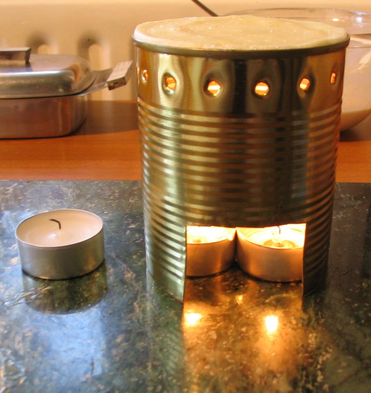 an open tin can sitting on top of a counter next to a lit candle holder