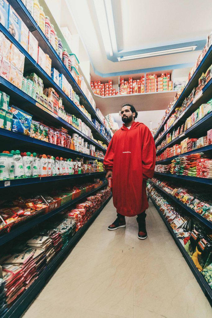 a man standing in the aisle of a grocery store surrounded by shelves filled with food