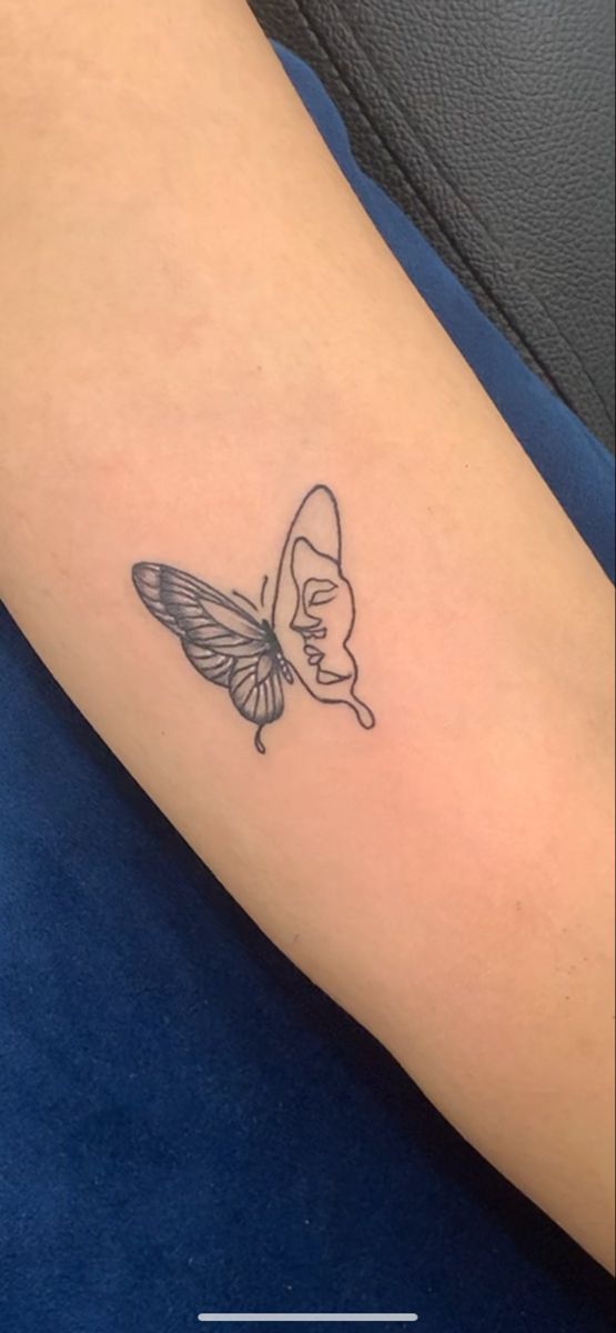 a small butterfly tattoo on the arm