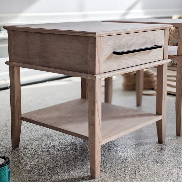 a small wooden table with two drawers on one side and an open drawer on the other