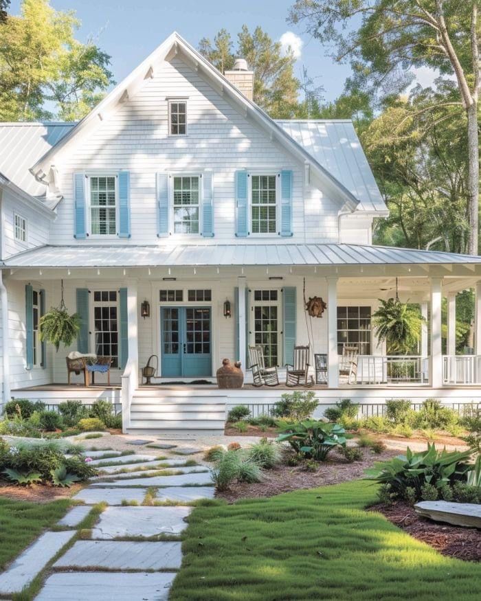 a white house with blue shutters in the front yard