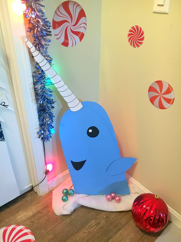 an inflatable narwhale sitting on the floor next to christmas decorations