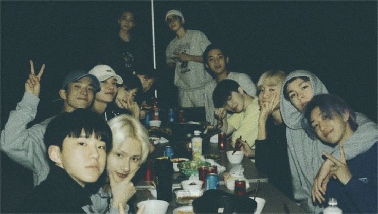 a group of people sitting around a table with food and drinks in front of them