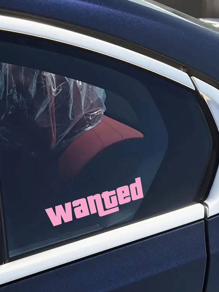 a car with the word wanted on it's side window and pink sticker