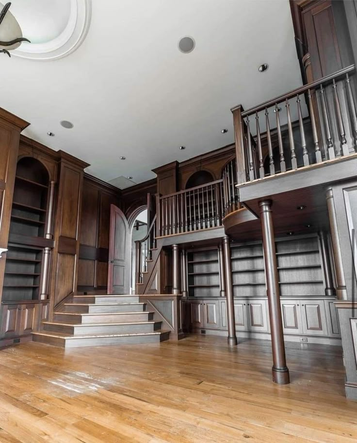 an empty room with wooden floors and bookshelves