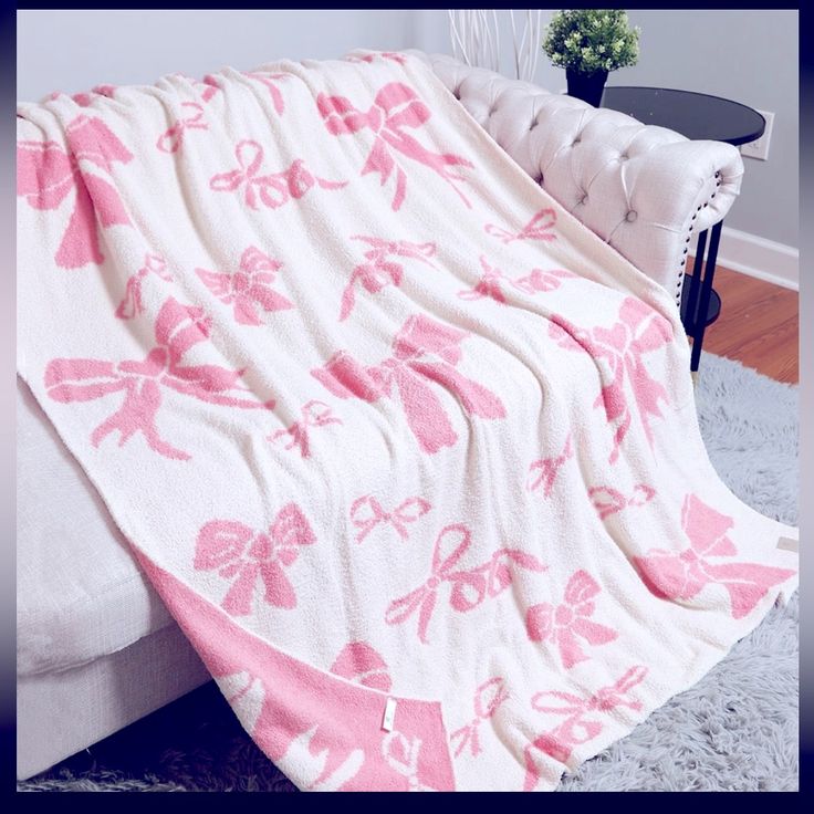 a pink and white blanket sitting on top of a bed