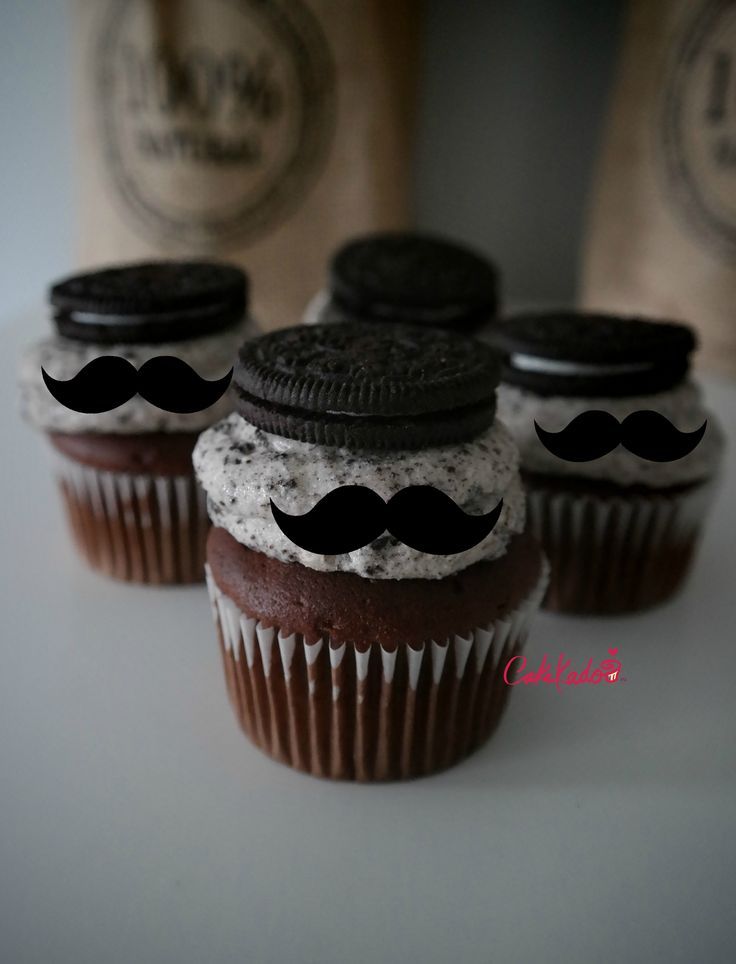 three cupcakes with oreo cookies and mustaches on them are sitting next to each other