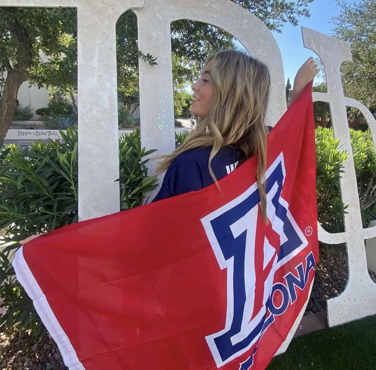 a woman holding a red flag in front of a white sign with the number 17 on it