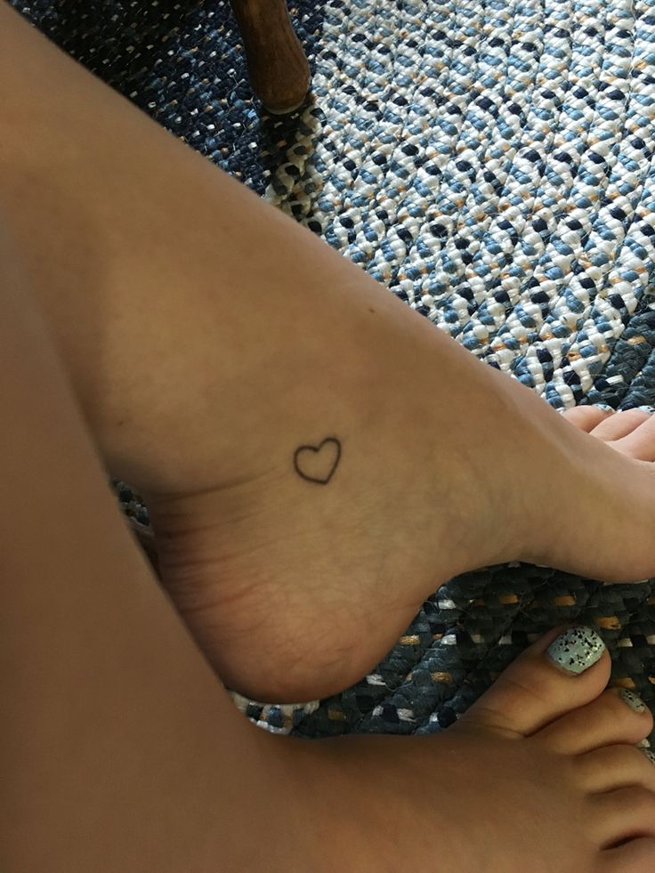 a person with a heart tattoo on their foot